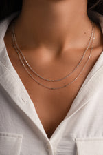 Dainty sterling silver layering necklace set by Sami Jewels featuring multiple delicate chain necklaces on a model.
