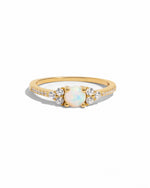 Dainty opal ring with gold band from Samijewels-527, showcasing a smooth white opal gemstone on a plain white background.