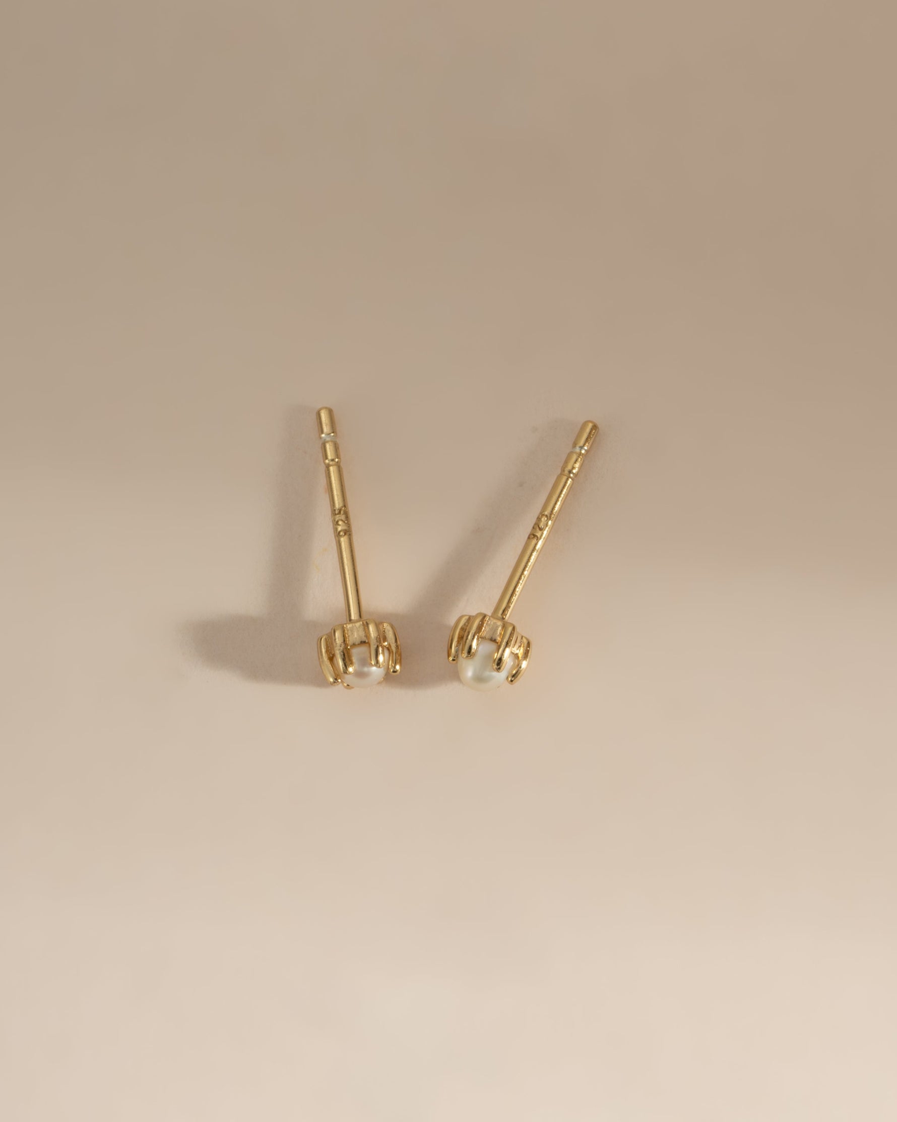 Gold top-view of dainty pearl stud earrings by Sami Jewels showcasing small, elegant pearl embellishments on classic earrings.