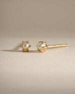 Dainty pearl stud earrings by Sami Jewels featuring small, round pearls set in gold for a delicate, elegant look.