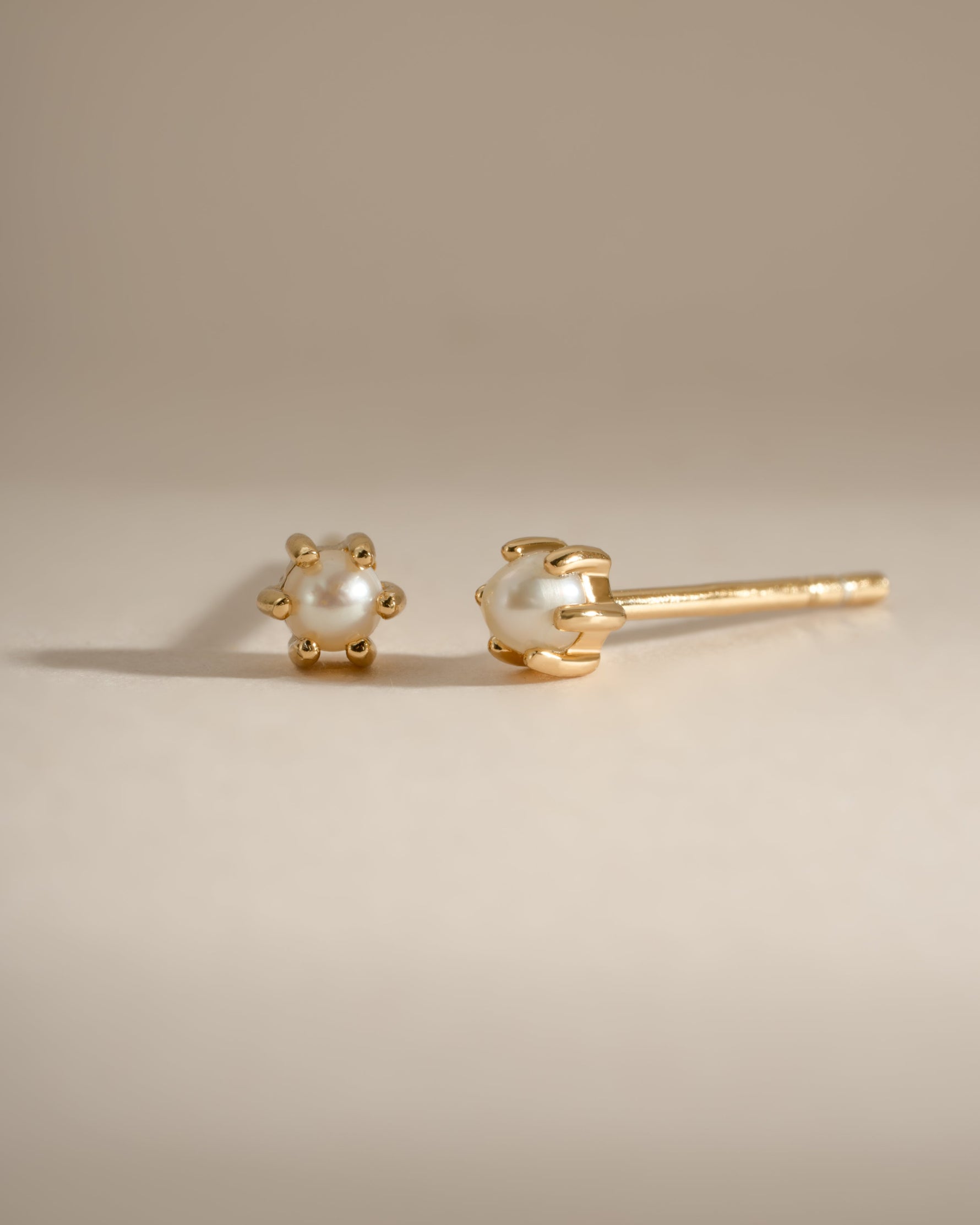 Dainty pearl stud earrings by Sami Jewels featuring small, round pearls set in gold for a delicate, elegant look.