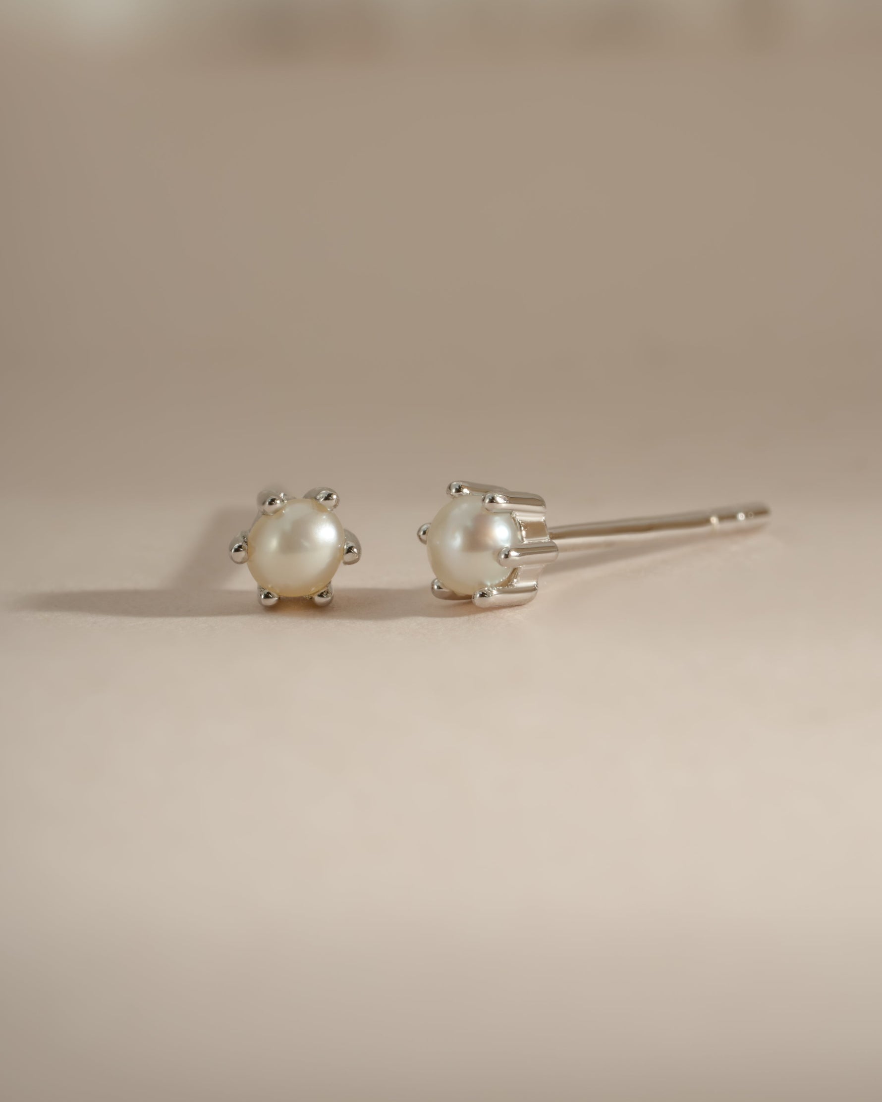Sterling silver dainty pearl stud earrings by Sami Jewels featuring small, elegant pearl accents on classic earring posts.