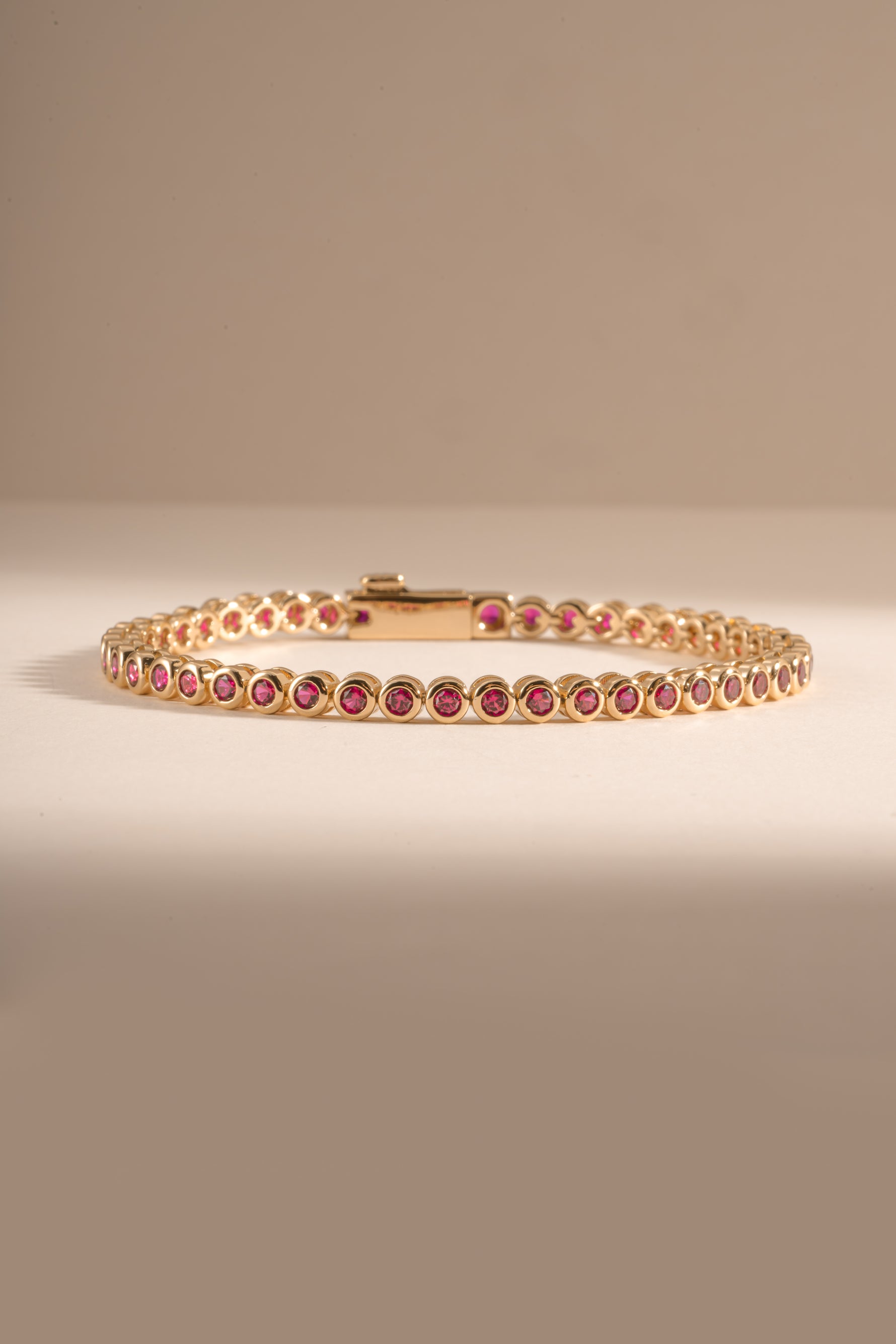 Dainty gold Ruby Bezel Tennis Bracelet by Sami Jewels featuring small round rubies set in a sleek gold bezel design.