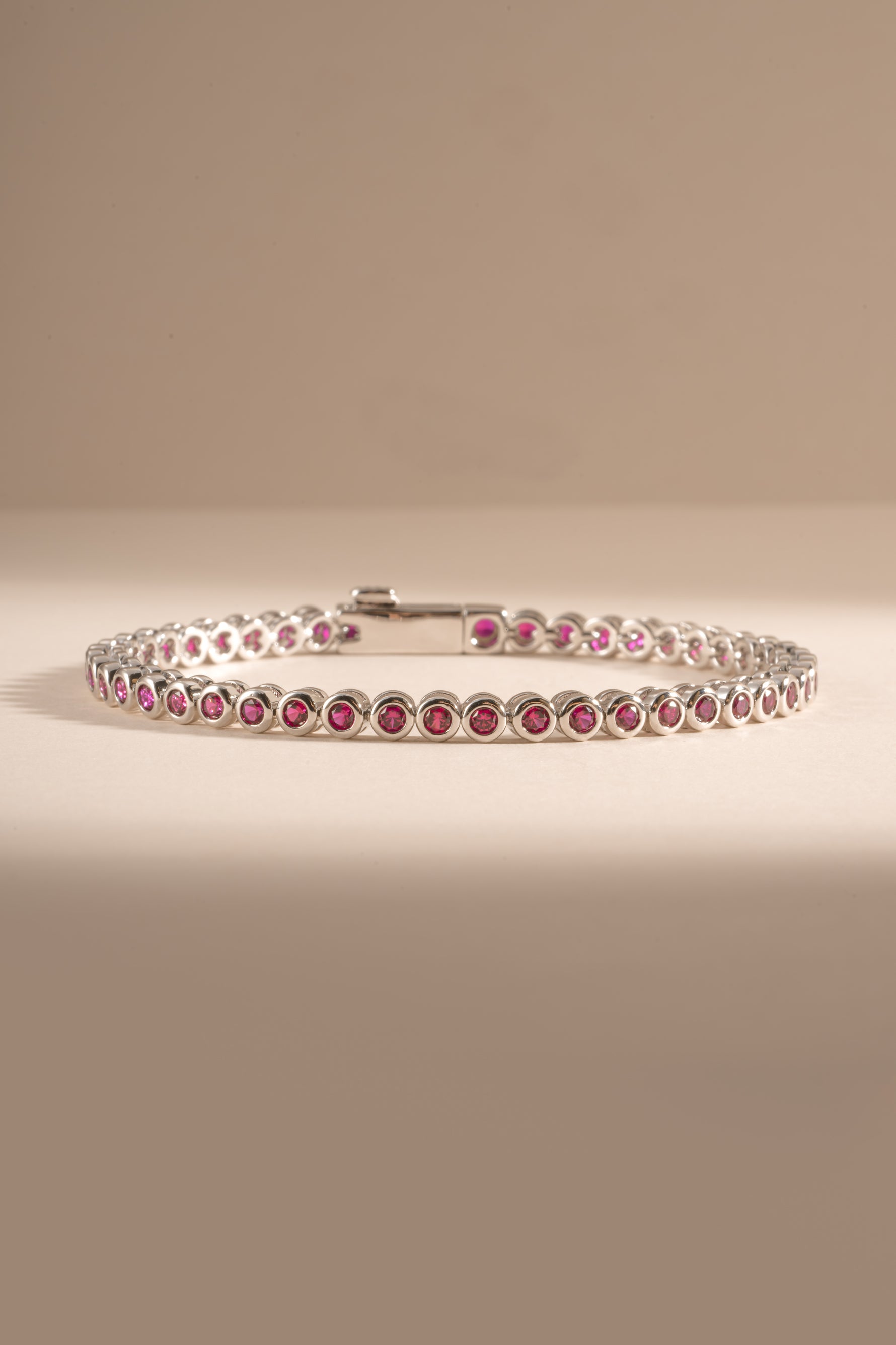 Dainty silver Ruby Bezel Tennis Bracelet by Sami Jewels featuring small red gemstones on a sleek bracelet design.