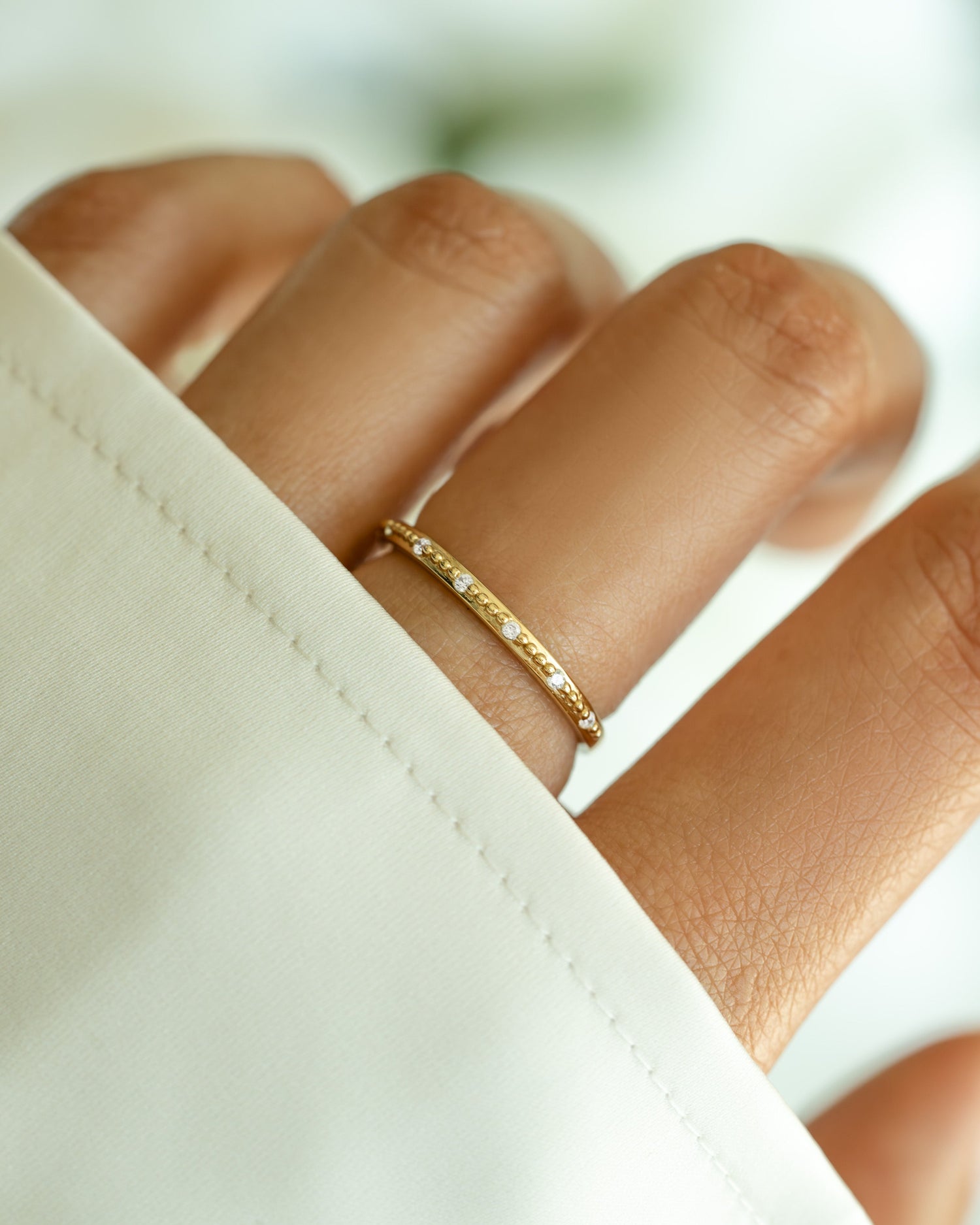 Dainty gold Mia stacking ring by Sami Jewels, shown on a model's finger, featuring a slim, elegant design perfect for layered jewelry.