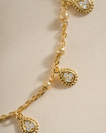 Close-up of Sami Jewels gold dangling tear drop necklace showcasing elegant design and fine craftsmanship.