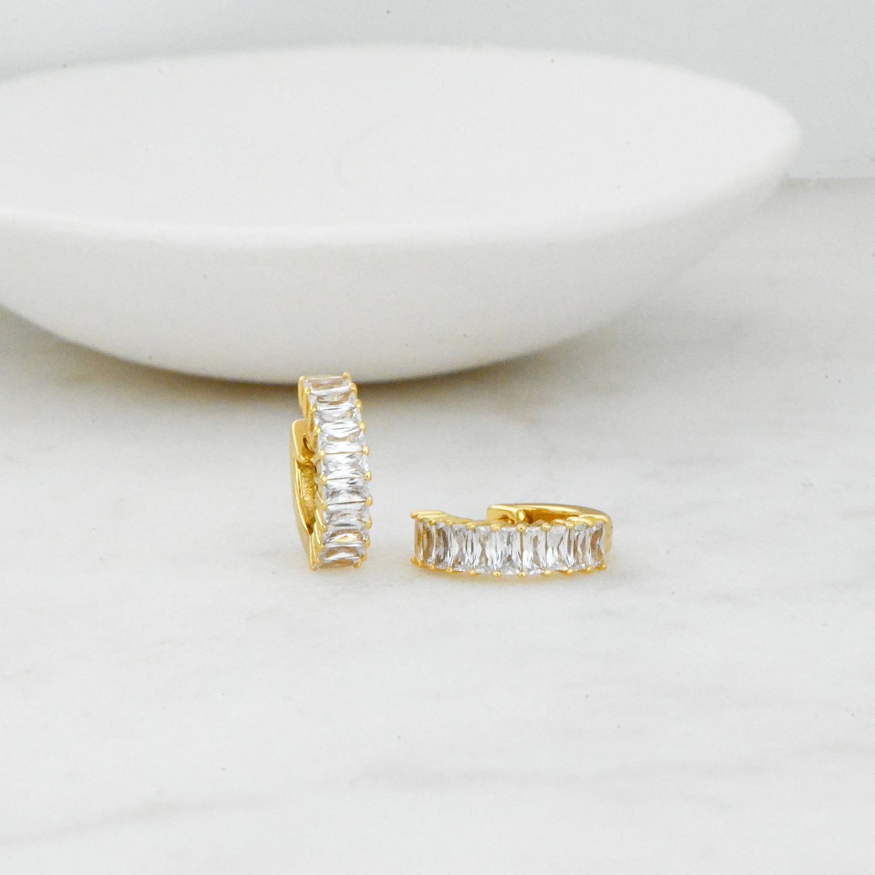 closeup image of 14k gold plated baguette huggie hoops