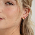 model wearing dainty hoop earrings with diamond huggies
