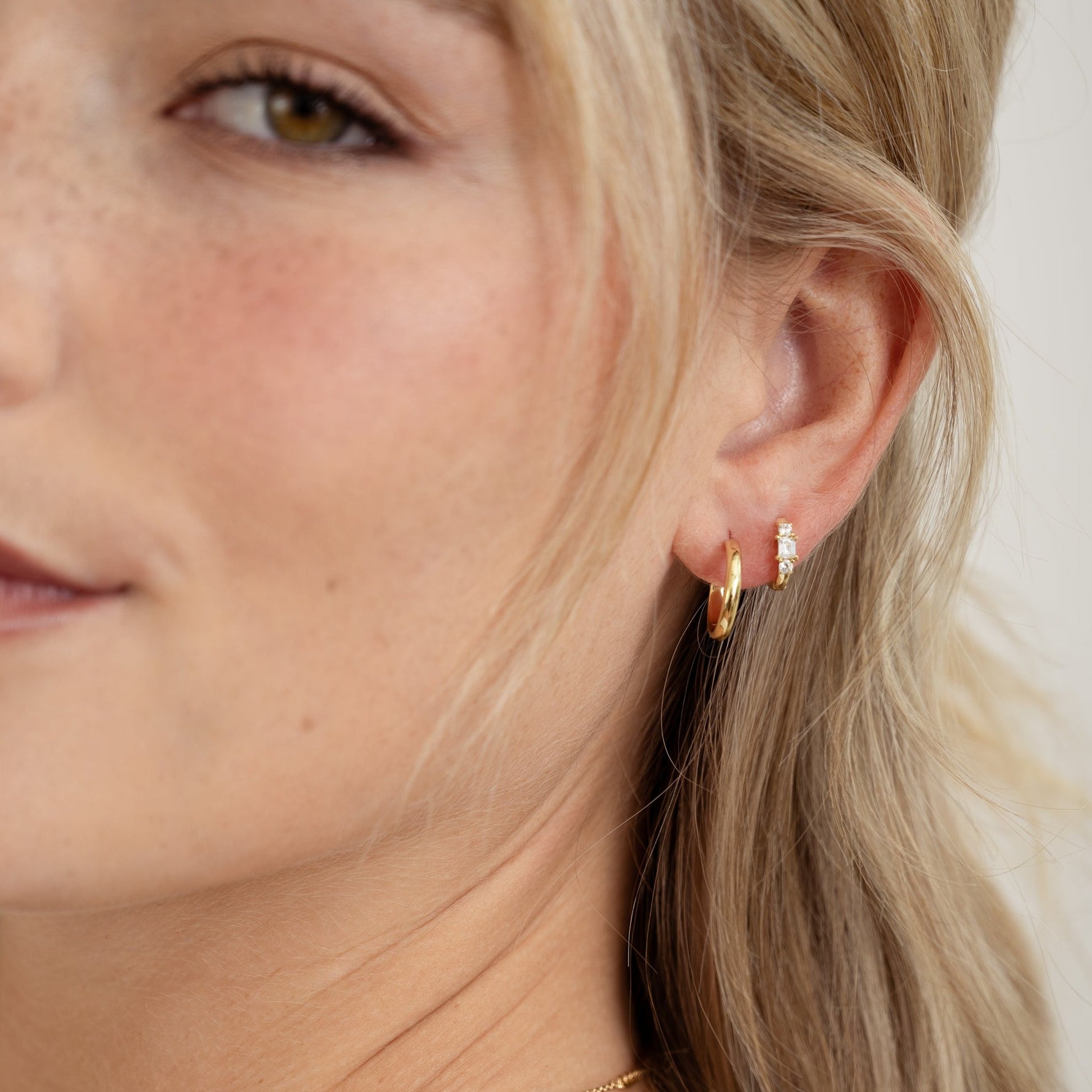model wearing dainty hoop earrings with diamond huggies