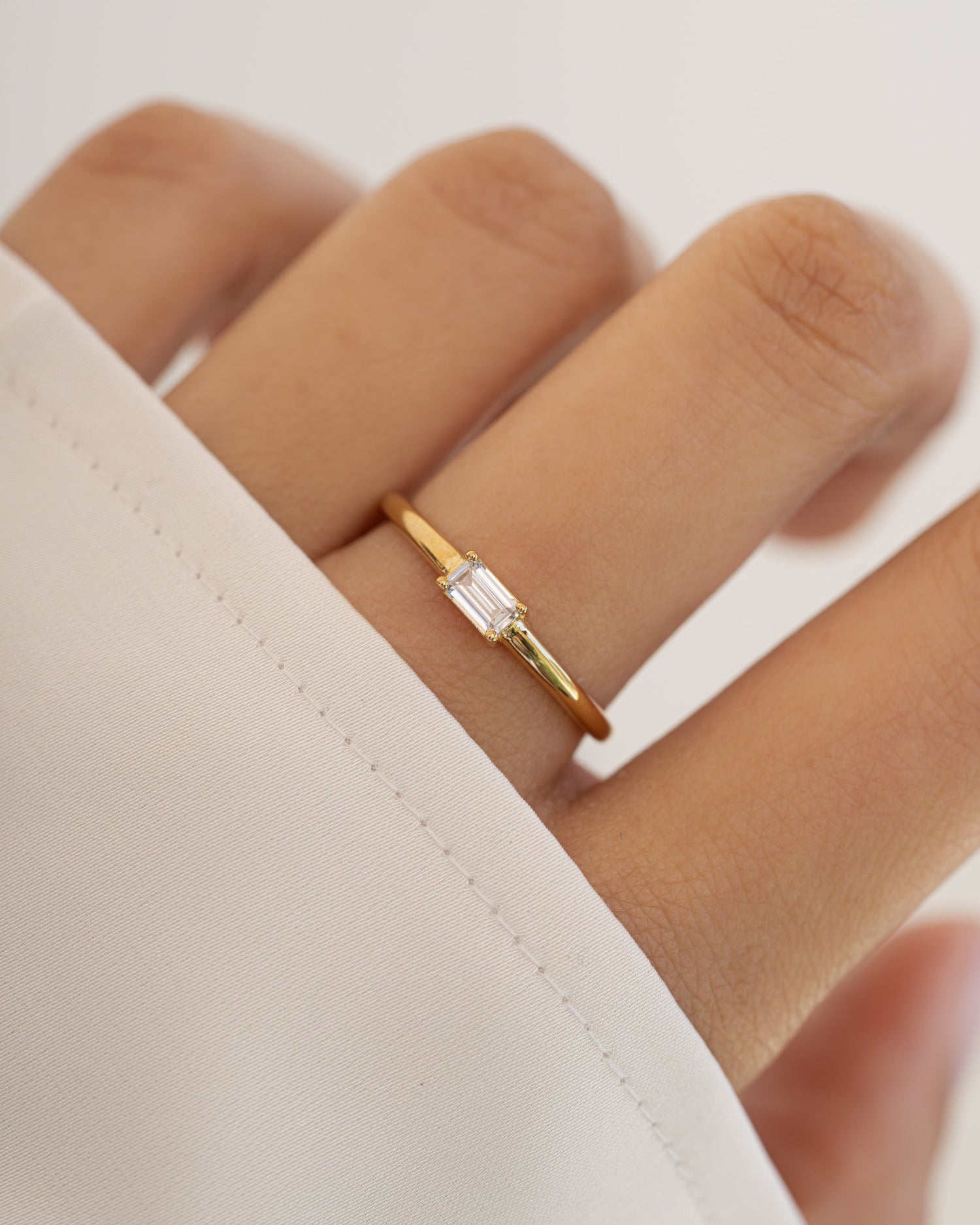 Sami Jewels Diamond Lori Baguette Ring on a model's finger, featuring gold band with rectangular diamond baguette accents.