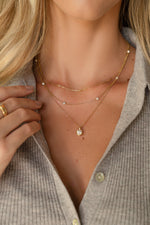 gold beaded pave necklaces layered on model