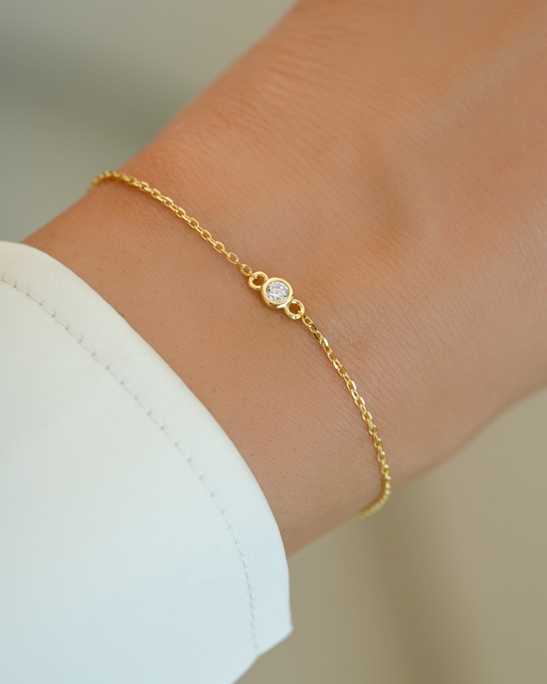 Gold diamond bezel bracelet by Sami Jewels featuring a sleek design and sparkling diamonds on a stylish model.