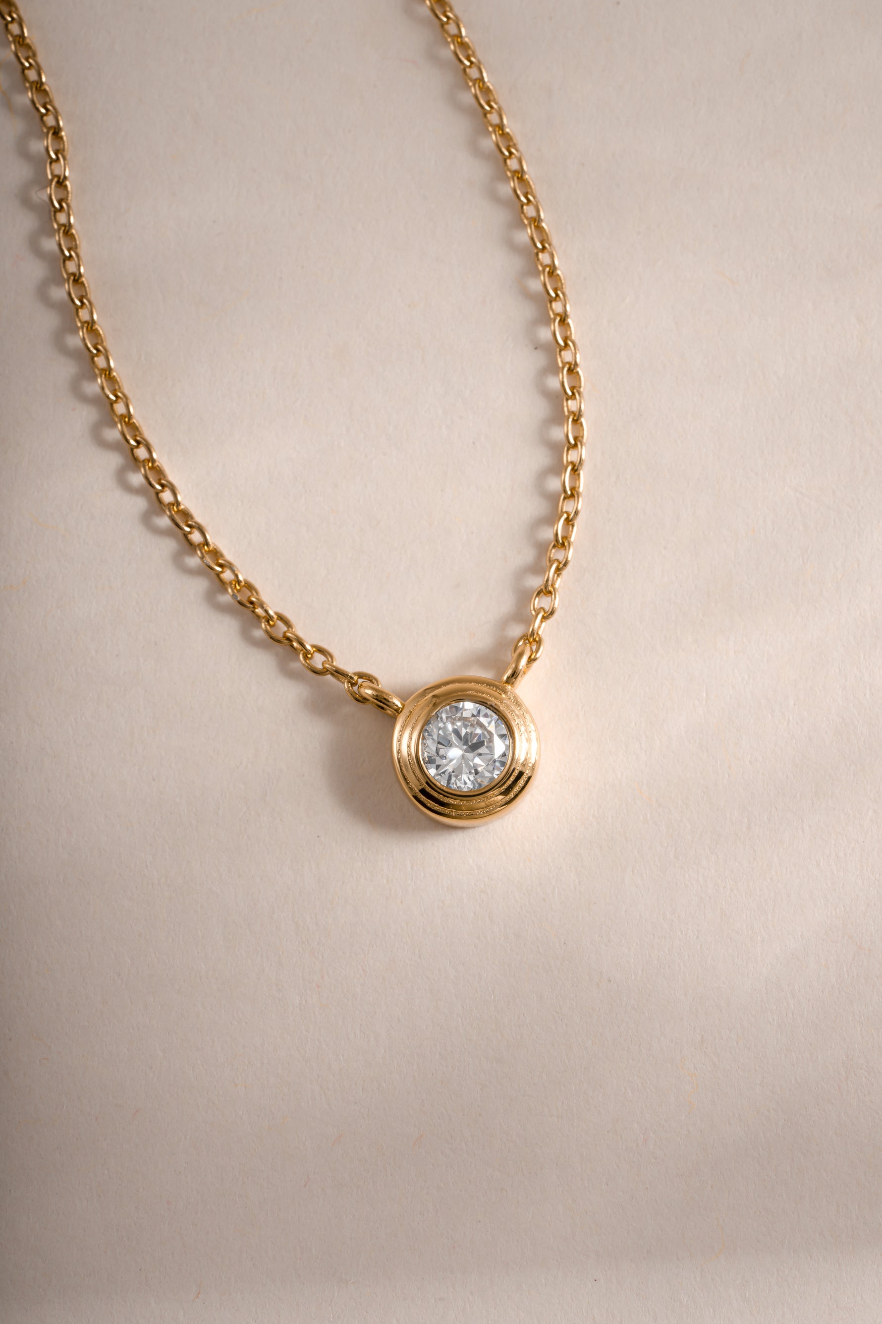 Close-up of Sami Jewels Tiny Bezel Necklace featuring a delicate diamond bezel pendant on a fine chain.