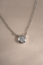 Close-up of Sami Jewels Tiny Bezel Necklace featuring a sterling silver chain with a small diamond bezel pendant.