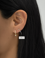 Close-up of an ear wearing a gold earring with a measurement label indicating 2.8mm.