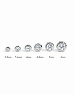 Sterling silver bezel stud earrings with diamond accents in various sizes, designed by Sami Jewels.