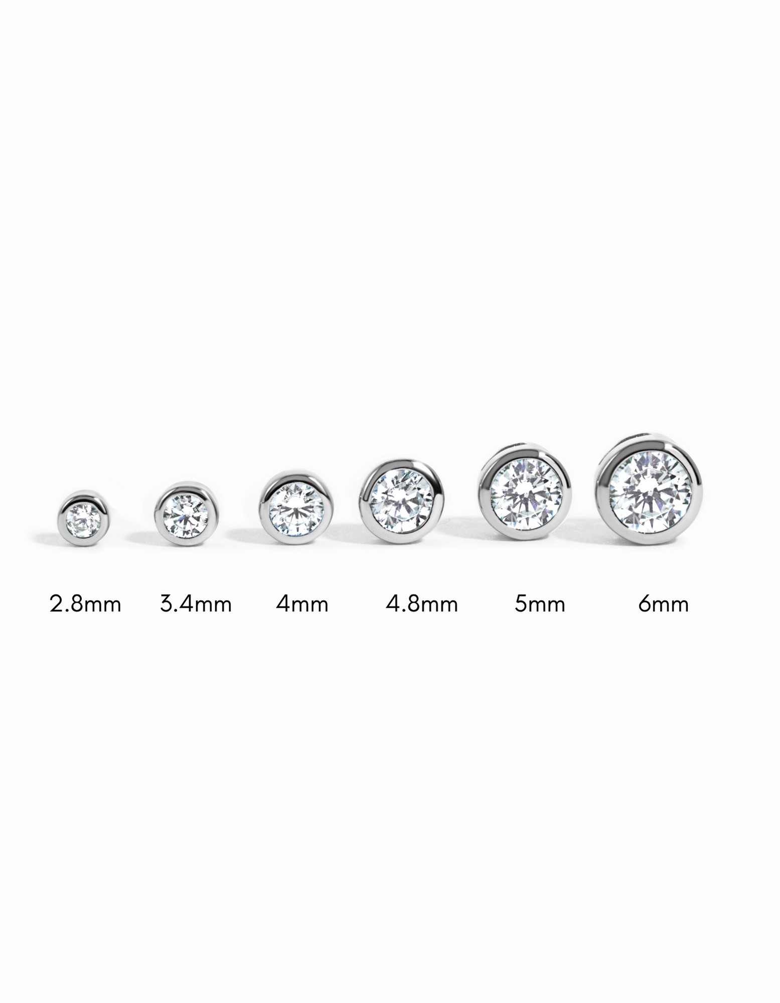 Sterling silver bezel stud earrings with diamond accents in various sizes, designed by Sami Jewels.