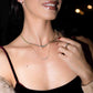 model is wearing a gold chain necklace with tiny diamond beads, layered with a simple gold necklace. they are also paired with dainty rings to complement the look.