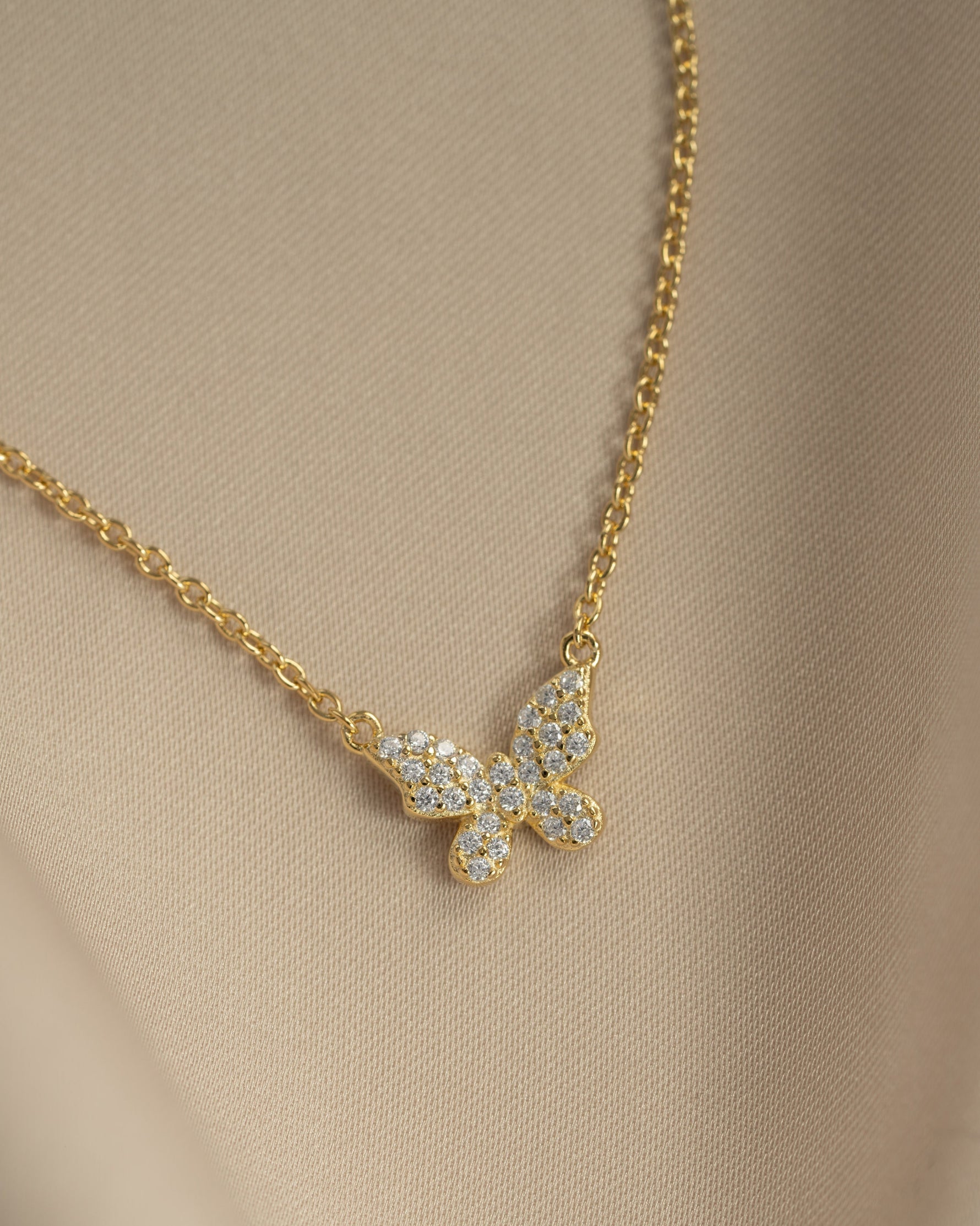 Close-up of Sami Jewels gold butterfly necklace with diamond accents, showcasing intricate design and delicate craftsmanship.