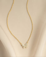 Gold butterfly necklace with diamond accents from Sami Jewels, showcasing a flatlay view of the elegant jewelry piece.
