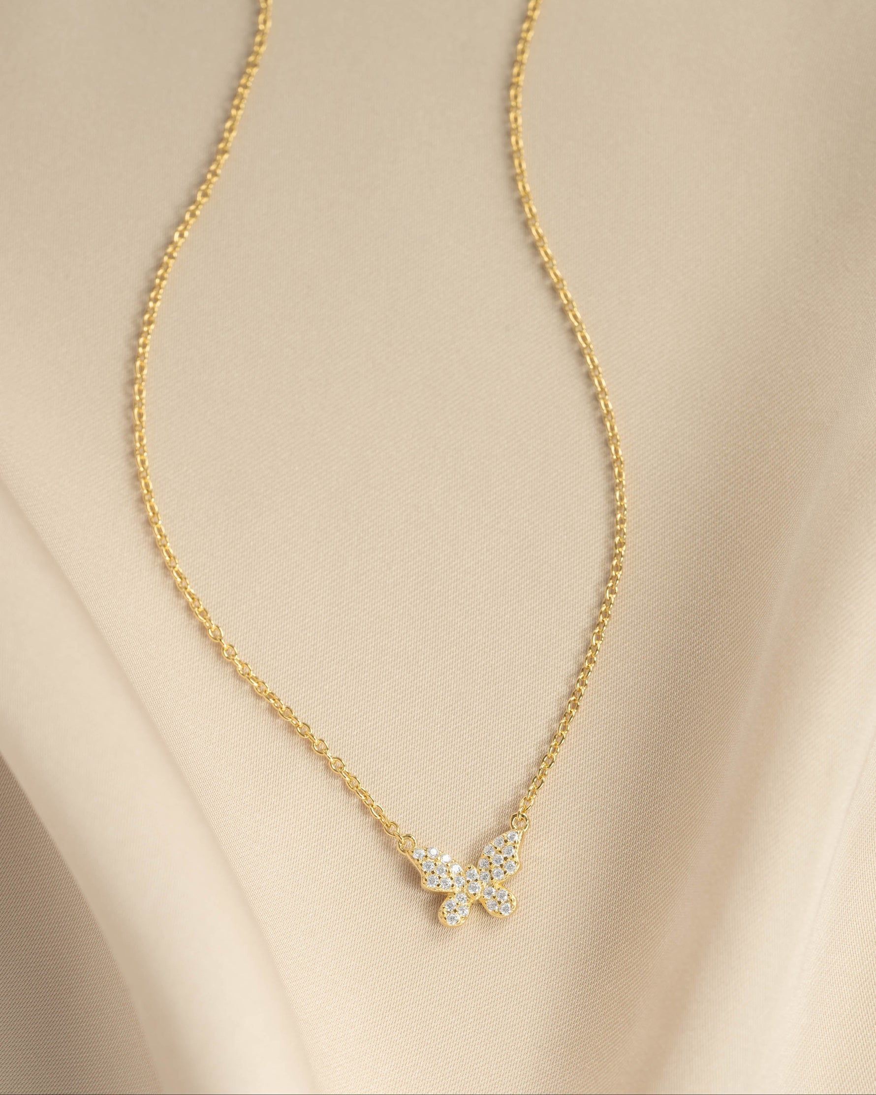 Gold butterfly necklace with diamond accents from Sami Jewels, showcasing a flatlay view of the elegant jewelry piece.