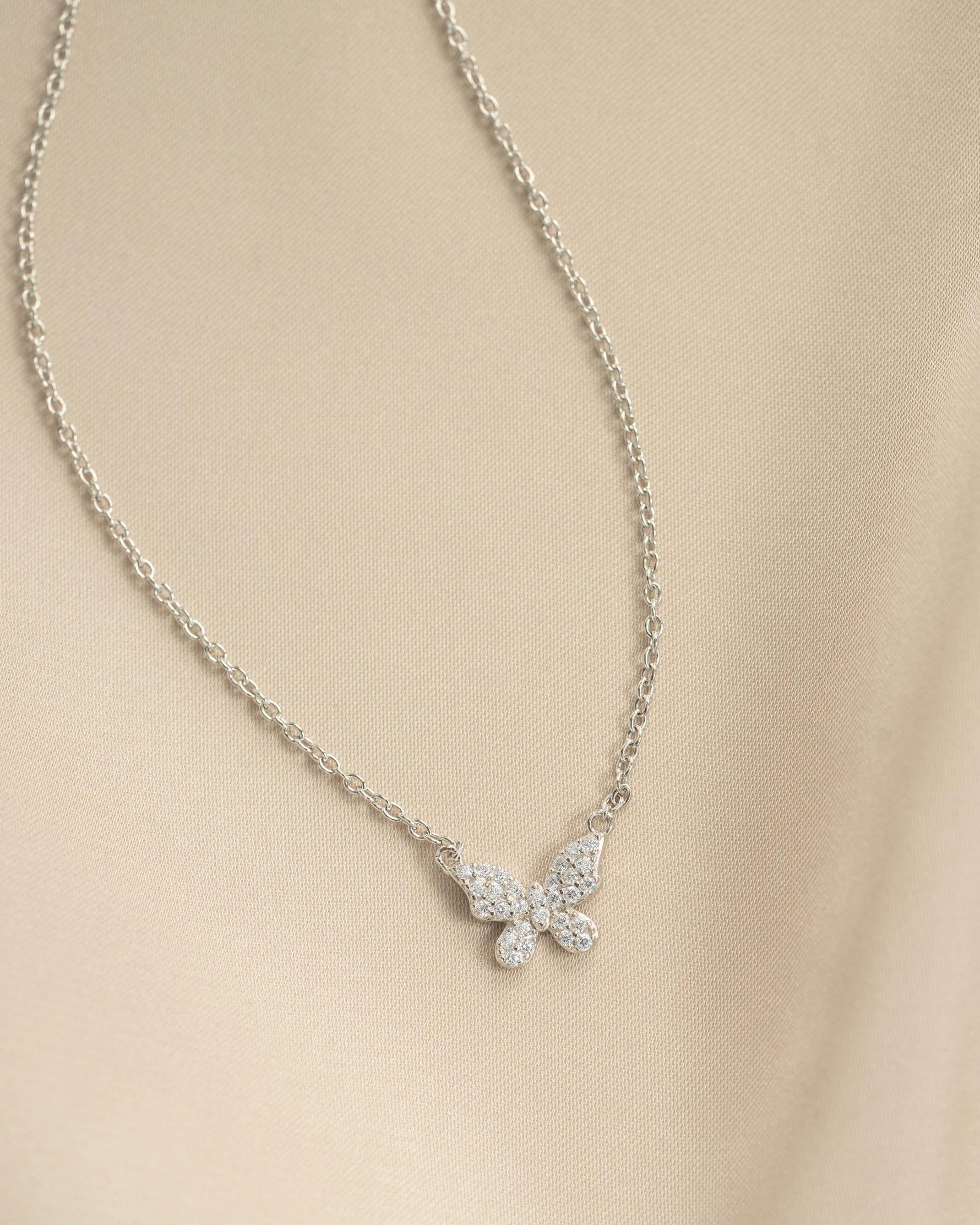 Close-up of Sami Jewels silver butterfly necklace with sparkling diamond accents, showcasing intricate design and sterling silver finish.