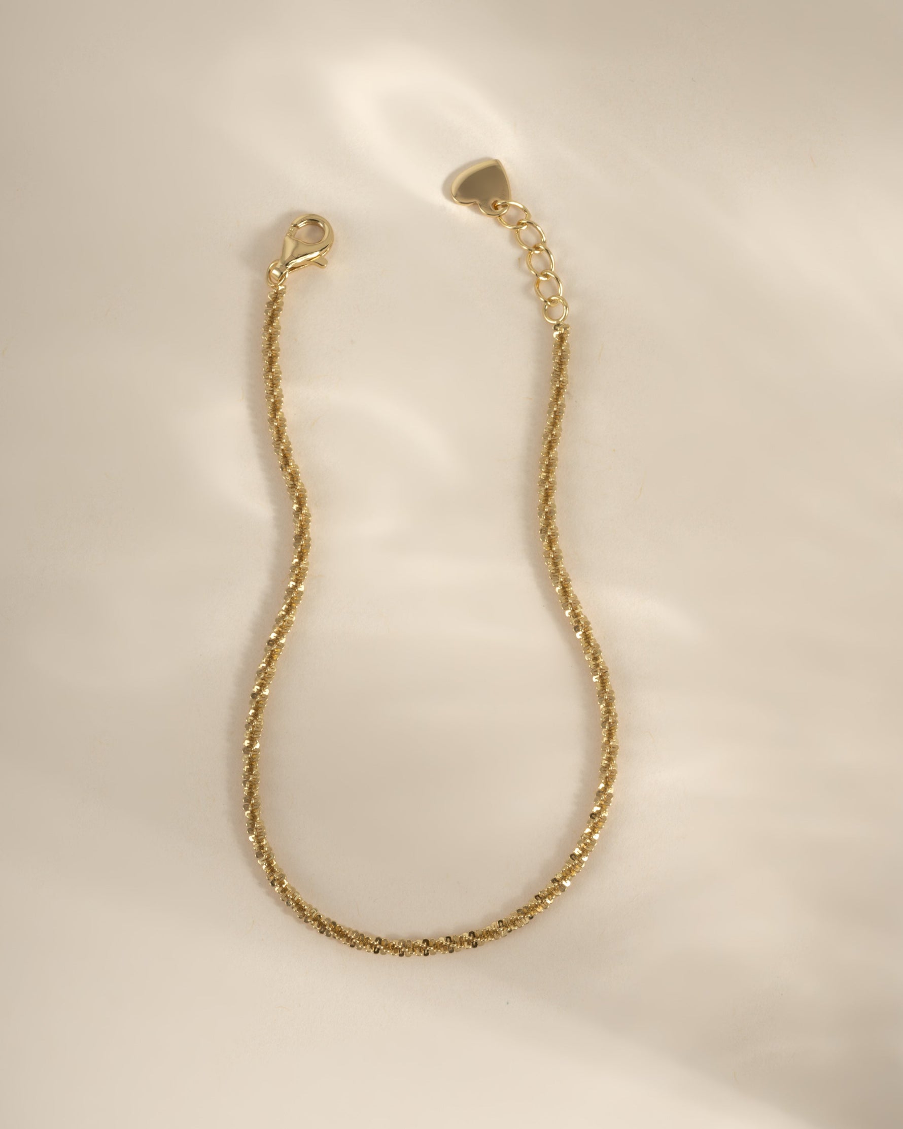 Close-up of a gold diamond-cut rope chain bracelet from Sami Jewels, showcasing intricate braided design and polished finish.