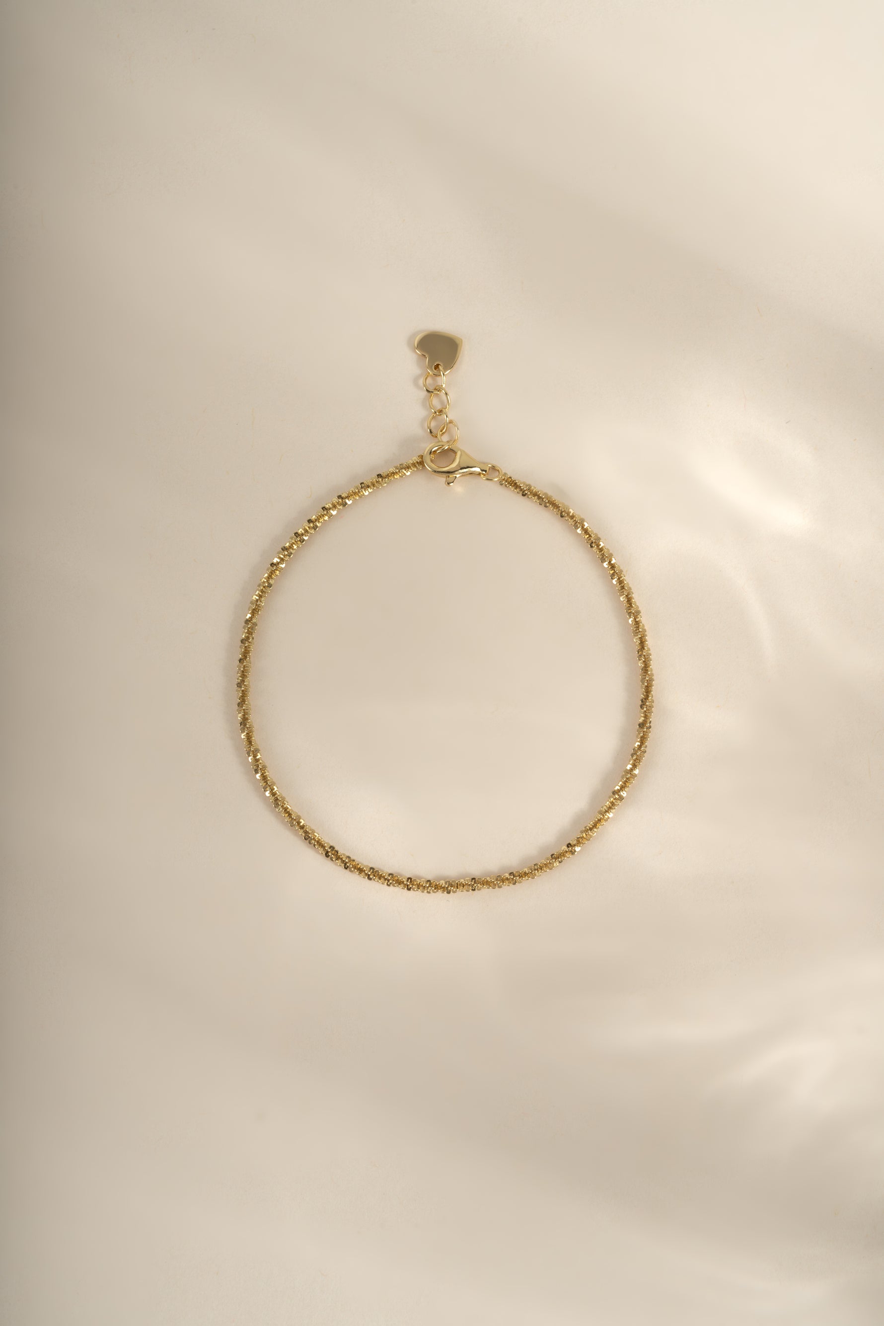 Gold Sami Jewels diamond-cut rope chain bracelet with intricate link design, showcasing shiny, textured surface.