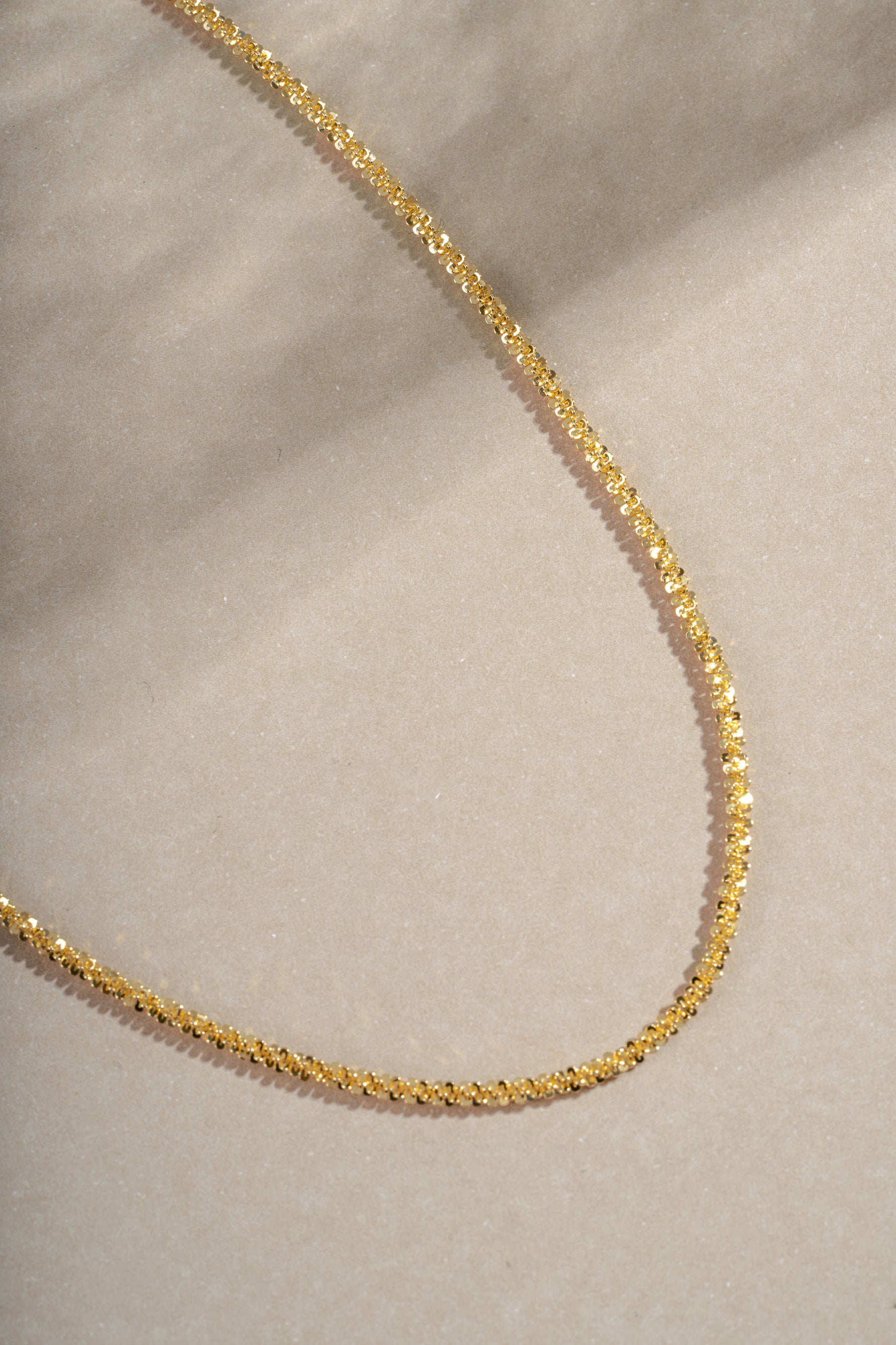 Close-up of a gold diamond-cut rope chain necklace from Sami Jewels showing intricate chain links and polished finish.