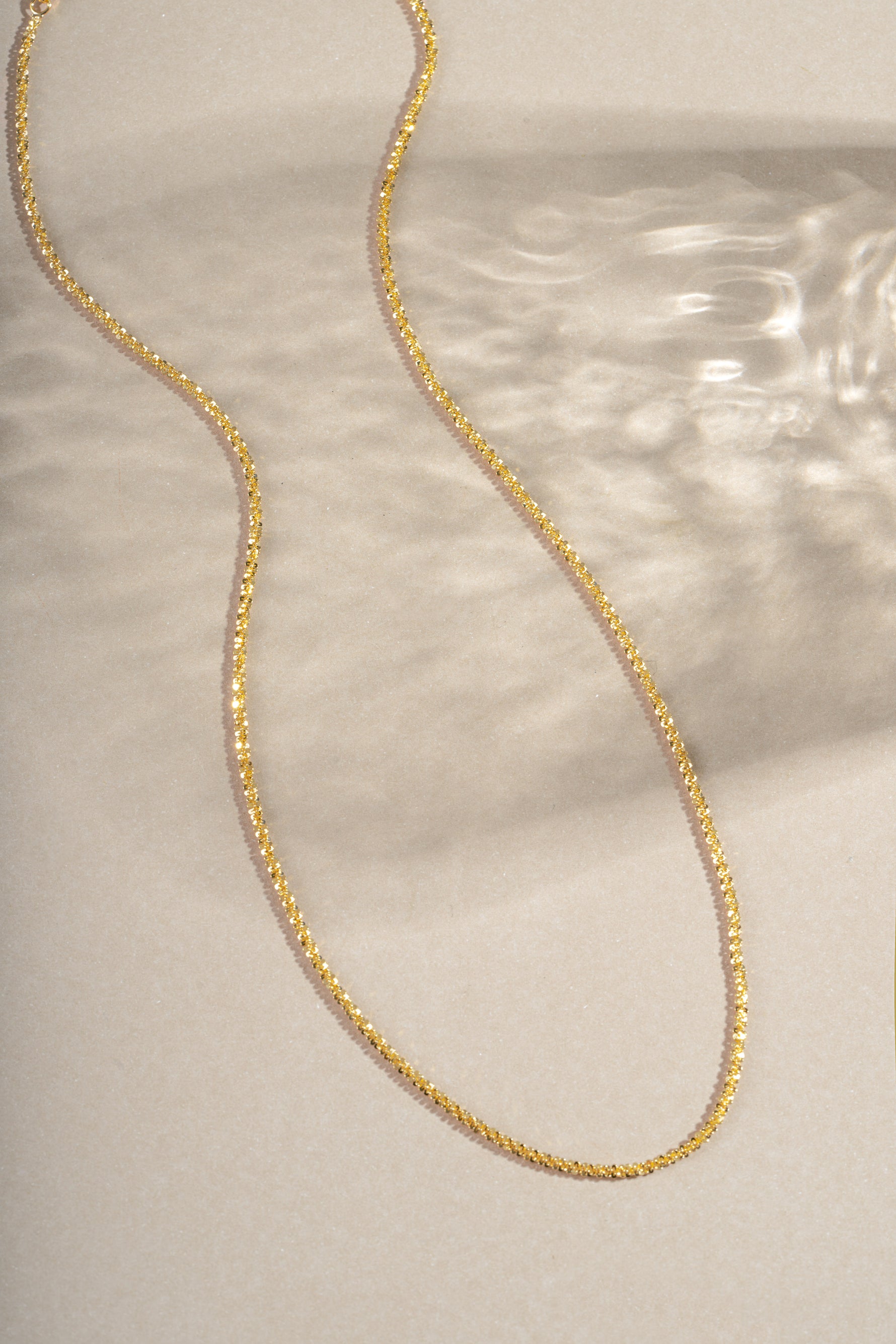 Gold diamond cut rope chain necklace from Sami Jewels, showcasing its intricate twisted design and shiny polished finish.