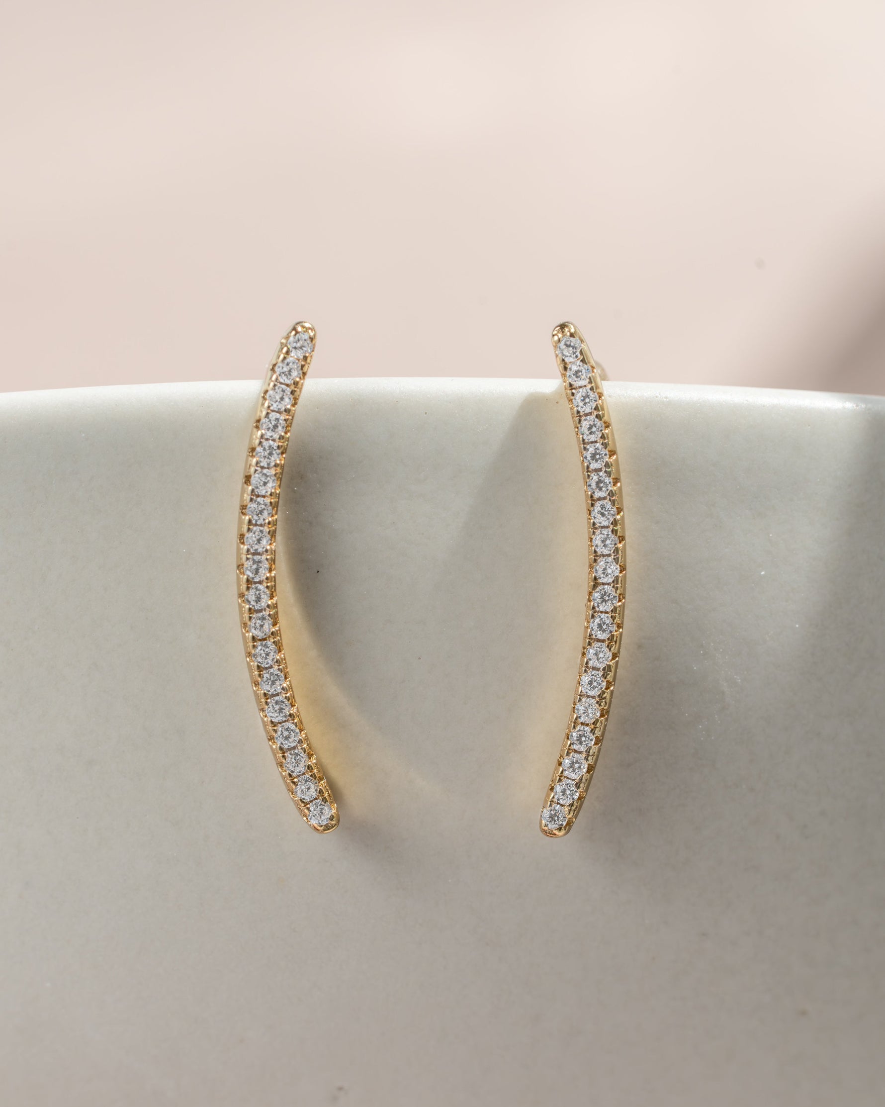 Close-up of Sami Jewels gold studded ear climber earring with diamond accents on a plain background.