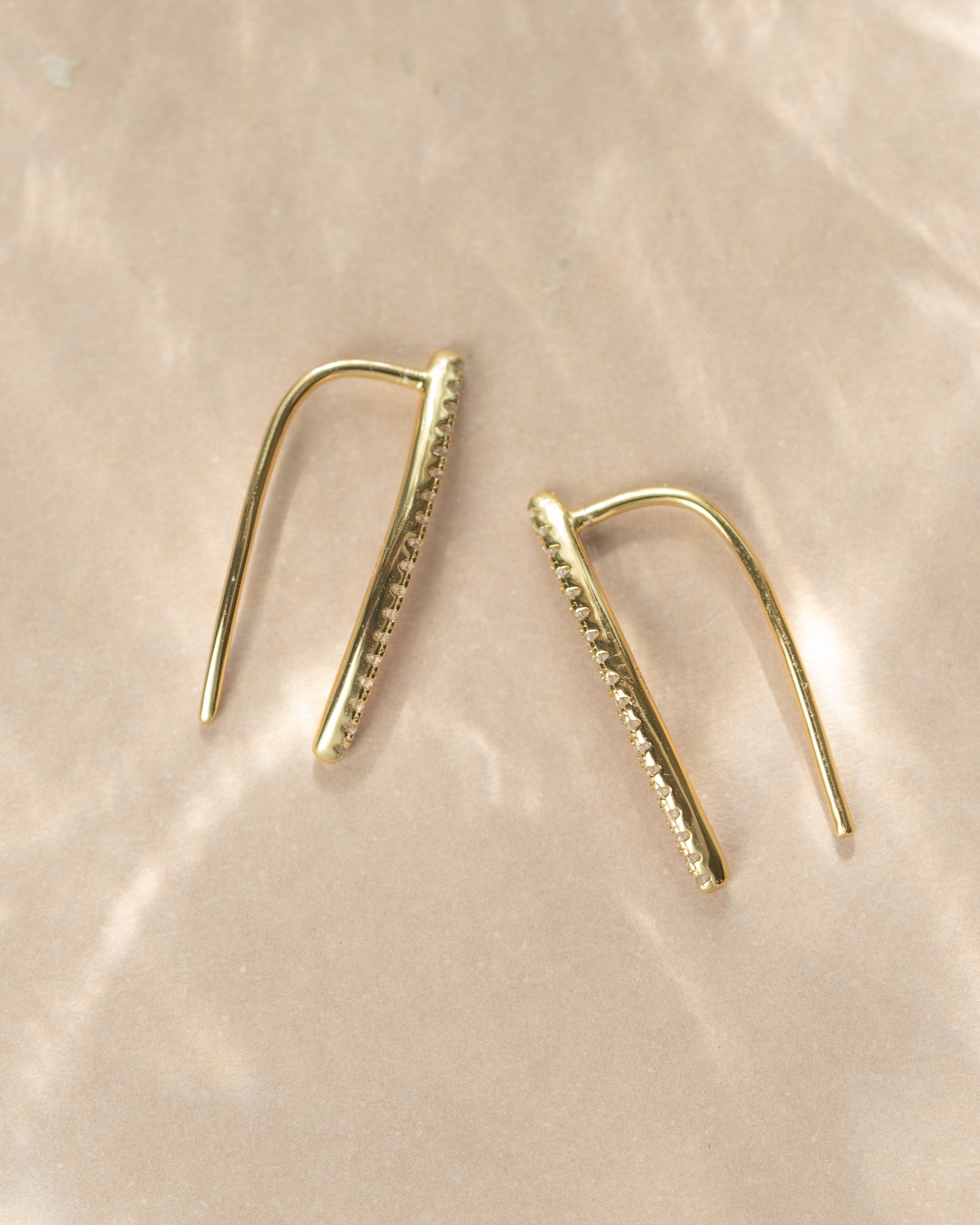 Gold studded ear climber earring by Sami Jewels displayed on a neutral background with diamond accents.