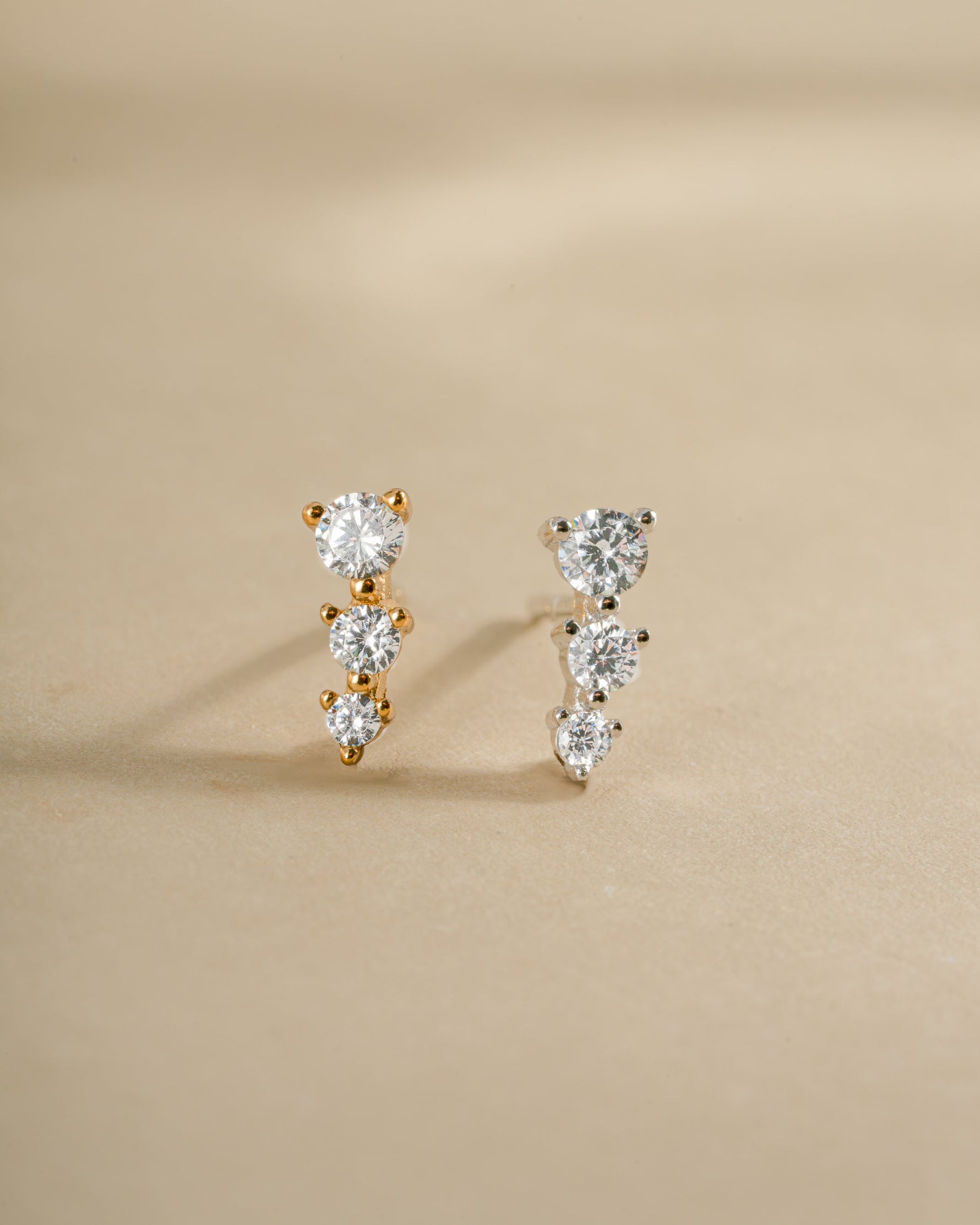 Diamond CZ ear climber earrings by Sami Jewels in gold and sterling silver, showcasing elegant, curved design on the ear.