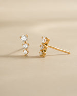 Close-up of gold CZ ear climber earrings by Sami Jewels with sparkling diamonds on a white background.
