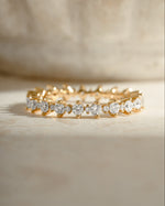 Sami Jewels Rebecca Eternity Ring with diamond accents on a gold band, front view showing continuous row of sparkling diamonds.