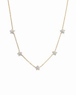 Gold diamond flower necklace by SJ Faire featuring a delicate floral charm on a chain, displayed against a white background.