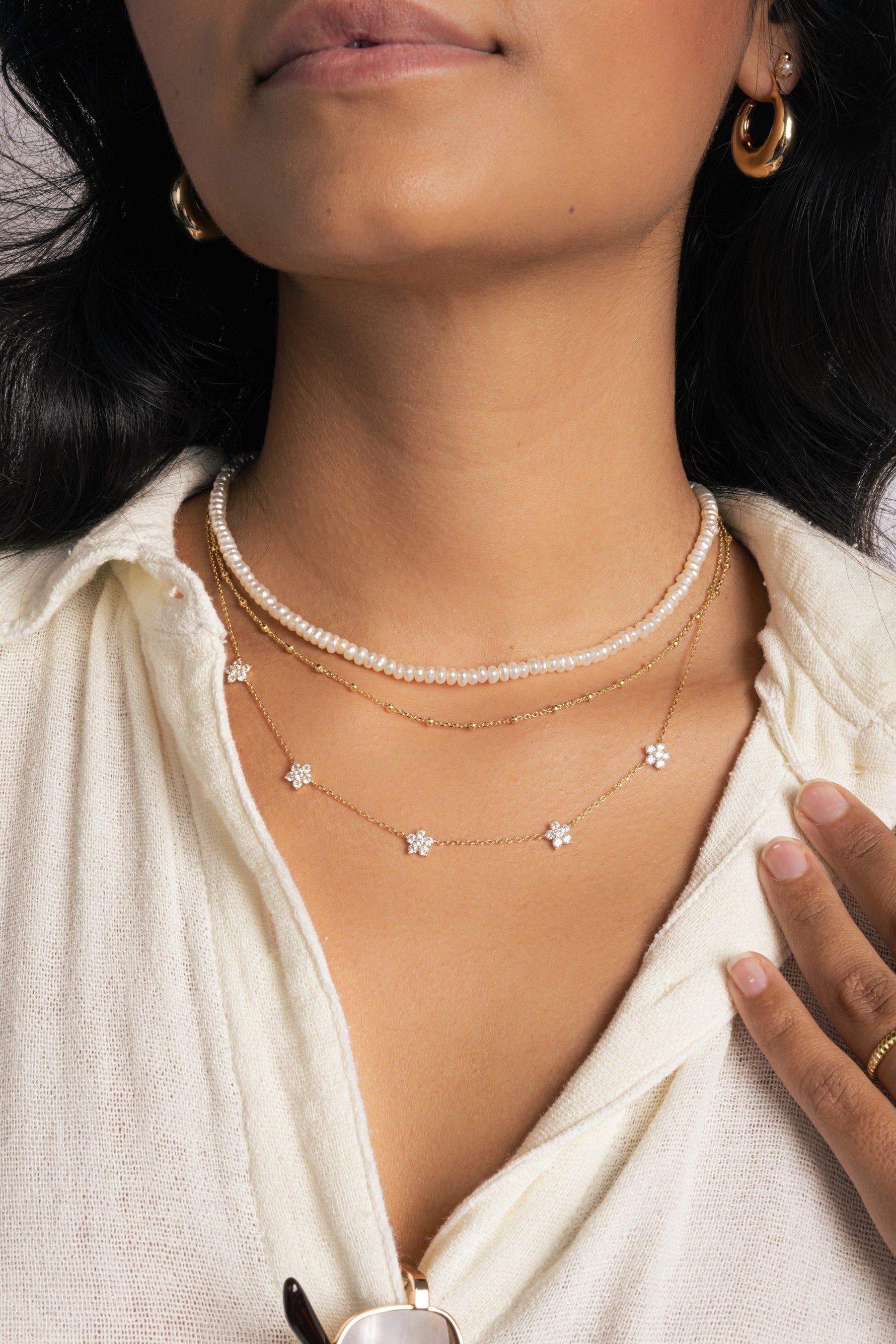 Gold Diamond Flower Necklace by SJ Faire featuring a delicate flower charm on a fine chain, styled on a model.