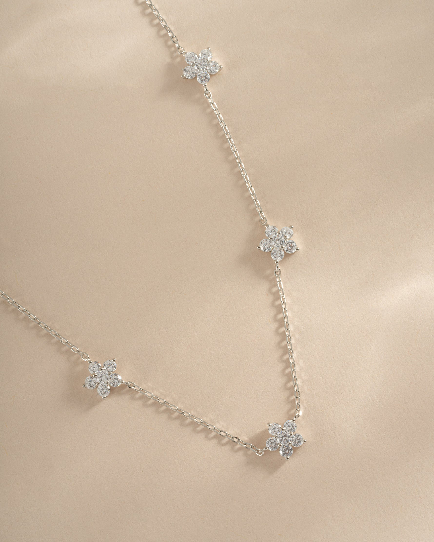 Close-up of SJ Faire diamond flower necklace in sterling silver, showcasing intricate flower-shaped pendant with sparkling diamonds.