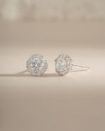 Sterling silver diamond halo stud earrings by Sami Jewels featuring round-cut diamonds in a halo setting.