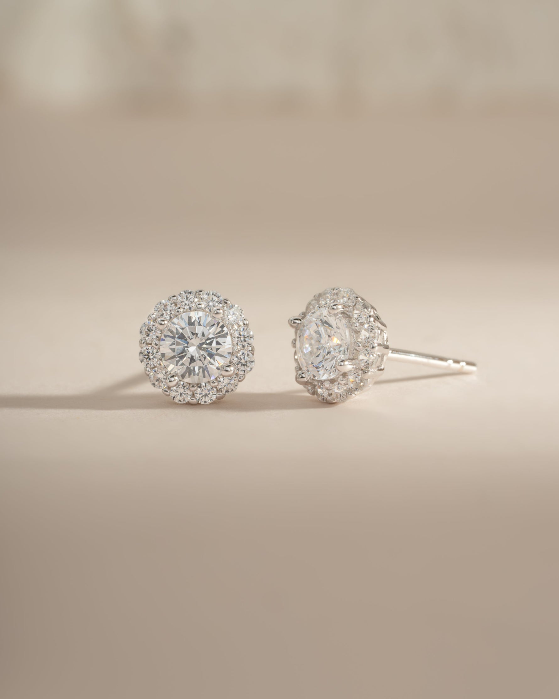 Sterling silver diamond halo stud earrings by Sami Jewels featuring round-cut diamonds in a halo setting.