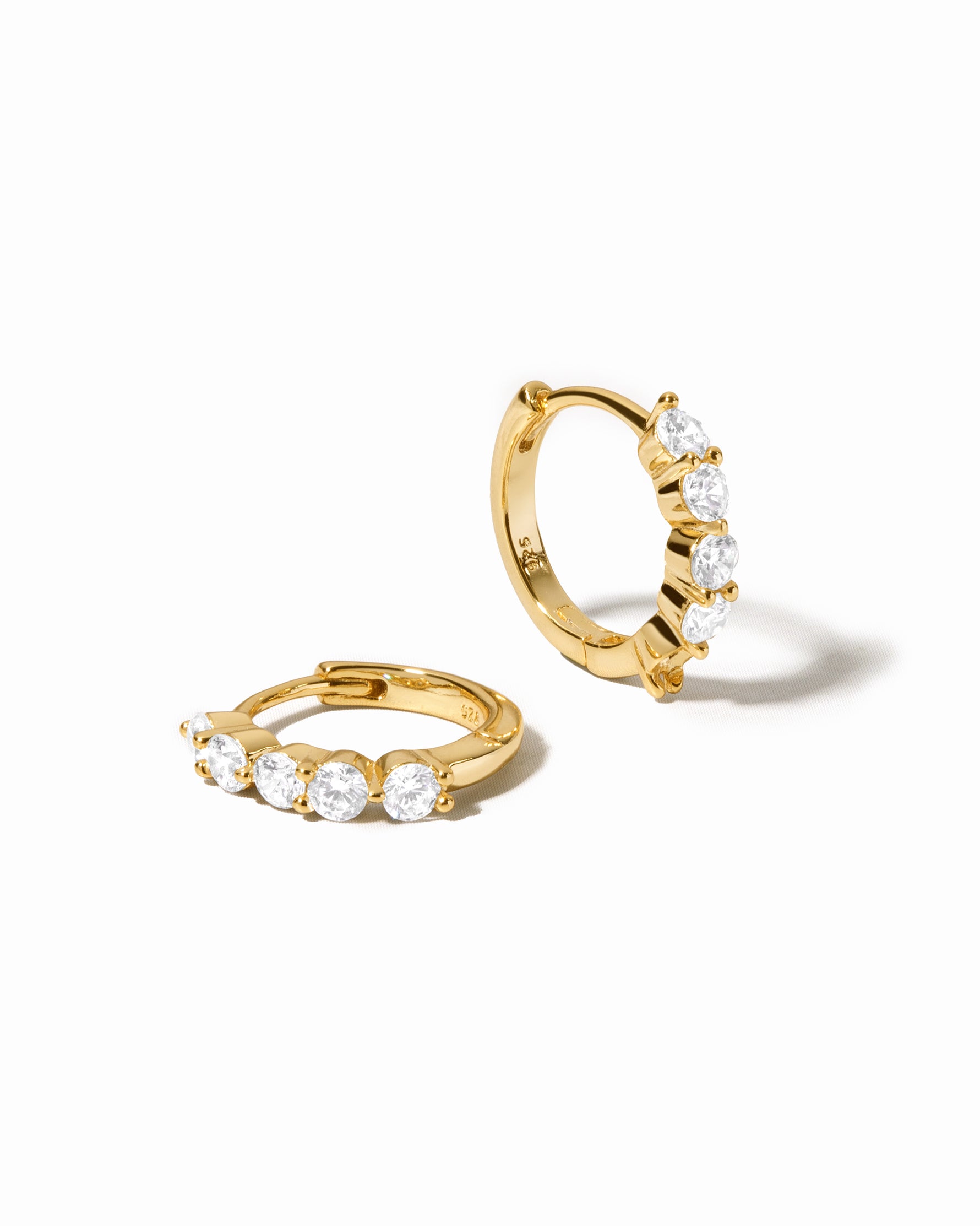 diamond huggie hoop earrings in 10mm in gold on a white background