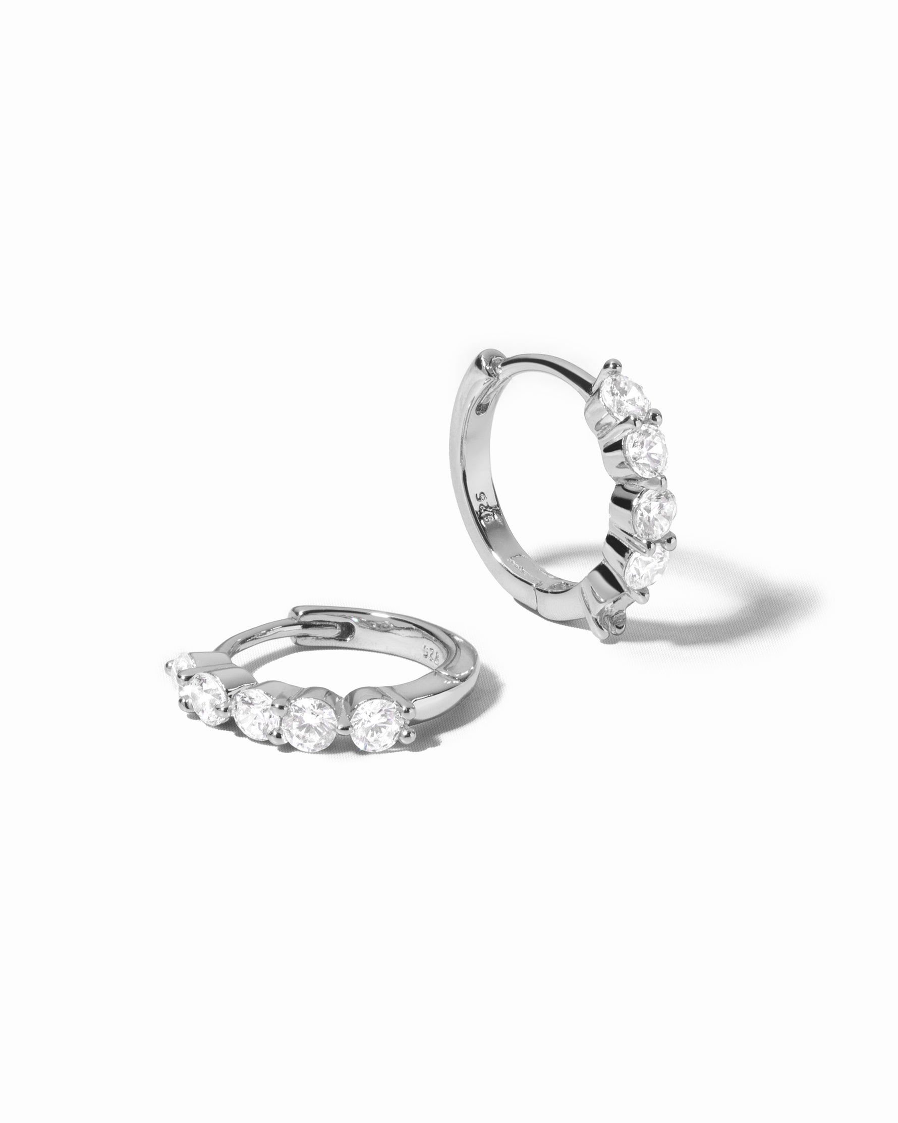 diamond huggie hoop earrings in 10mm in sterling silver on a white background
