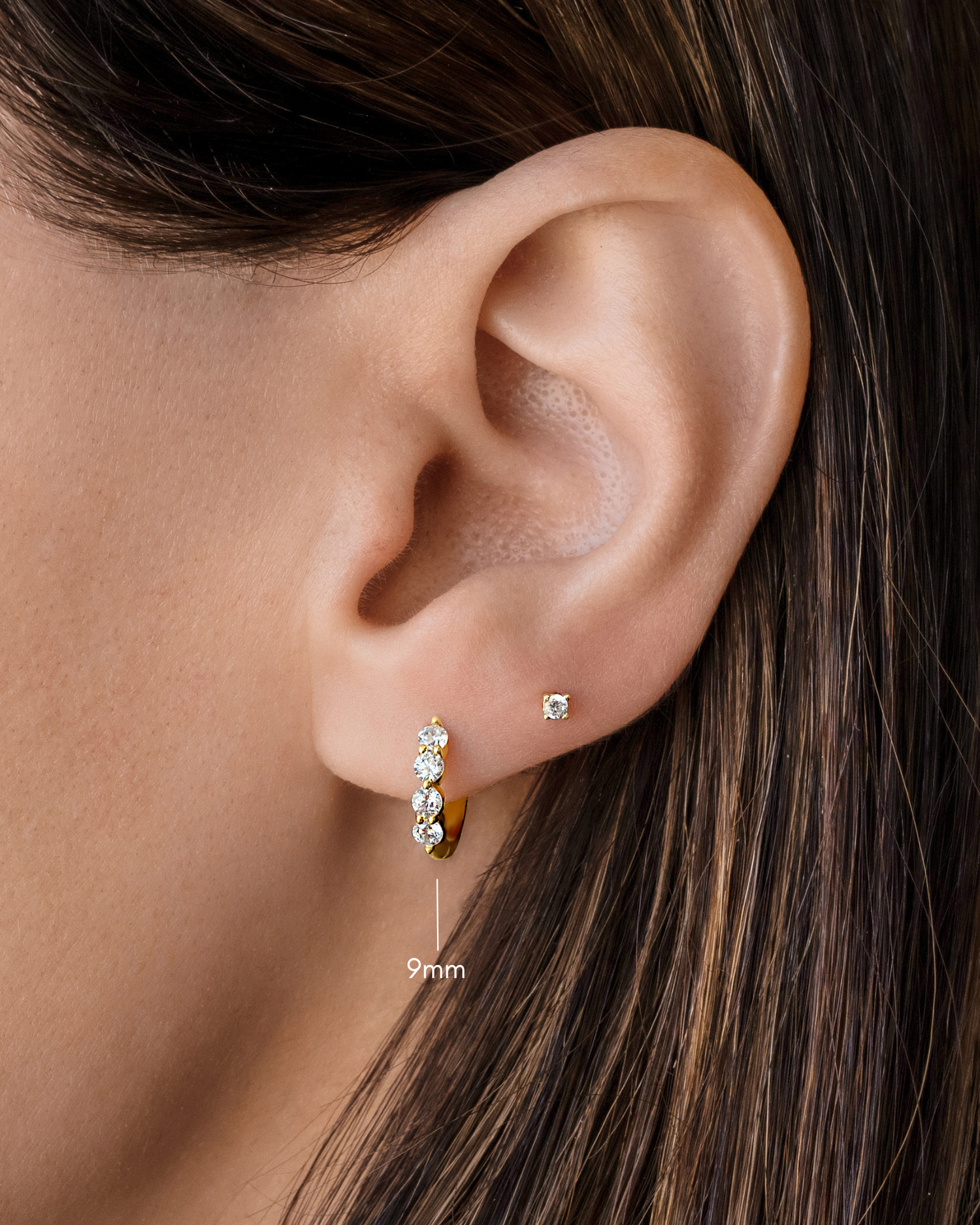 diamond huggie hoop earrings in 9mm in gold on a models ear