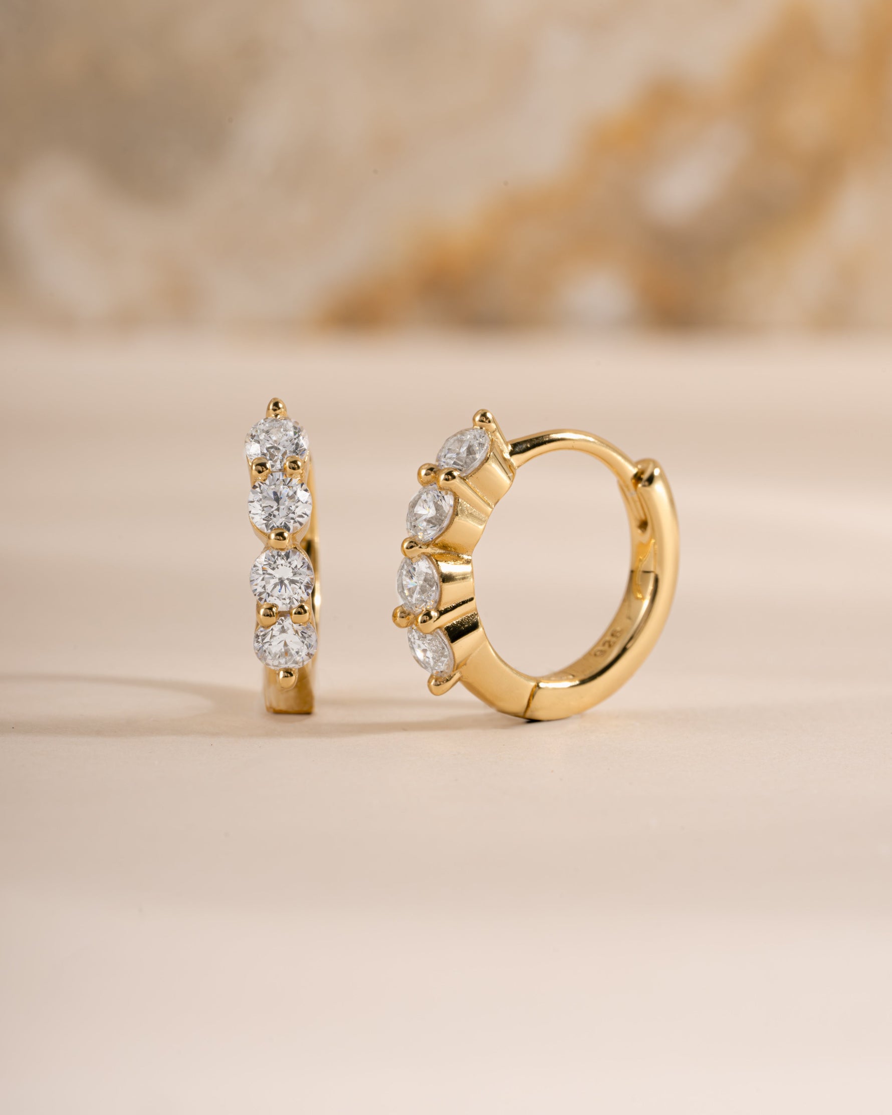 Sami Jewels 9mm gold diamond huggie hoop earrings shown from a side view, close-up of stylish jewelry design.