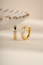 Gold diamond Huggie hoop earrings by Sami Jewels, featuring sparkling diamonds and a sleek, modern design.