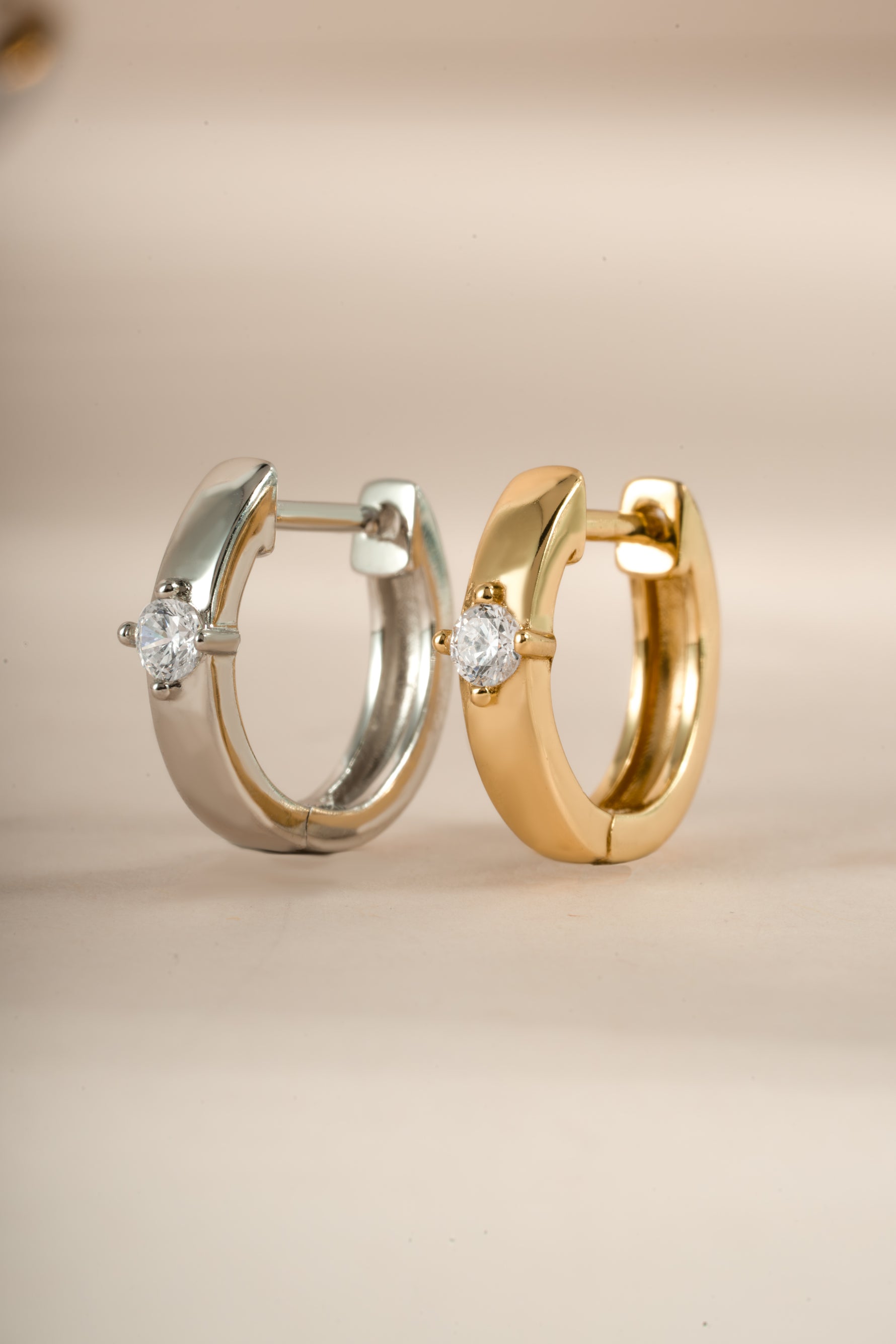 Sami Jewels Bella Huggie Hoop Earrings with diamond accents in sterling silver and gold, close-up of stylish jewelry.