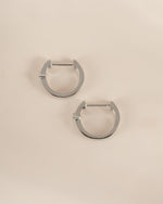 Sami Jewels Bella Huggie Hoop Earrings with sparkling diamonds in sterling silver, shown in a side profile view.