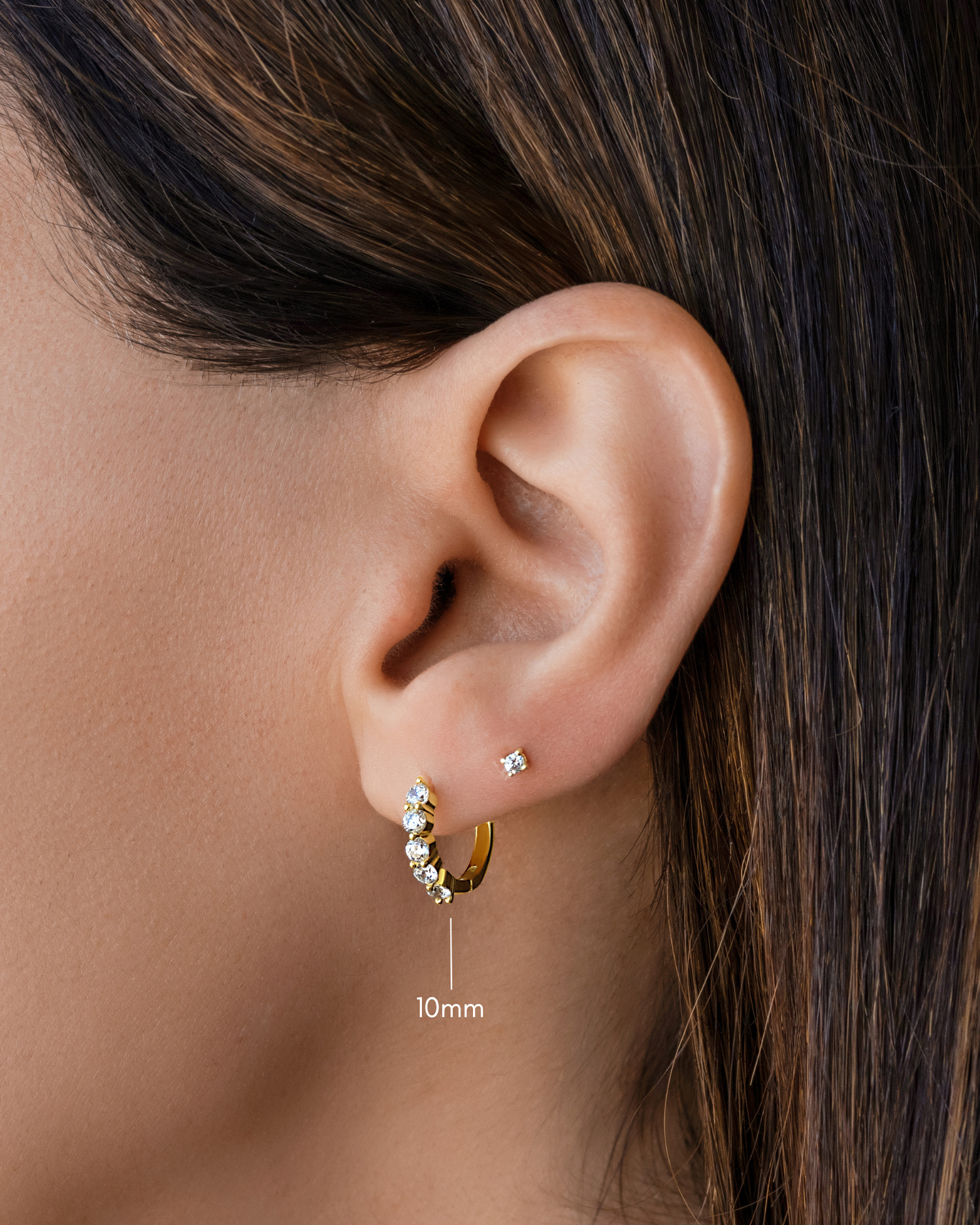 diamond huggie hoop earrings in 10mm in gold on a models ear