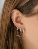 Stacked 8mm gold diamond-huggie hoop earrings by Sami Jewels worn on a model. Elegant and stylish jewelry accessory.