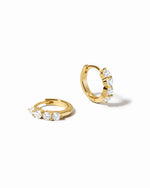 diamond huggie hoop earrings in 9mm in gold on a white background